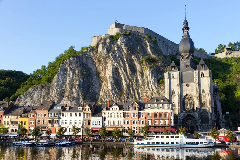 Stad aan het water tegen een berg aan met onder anderen een kerk en boten in het water