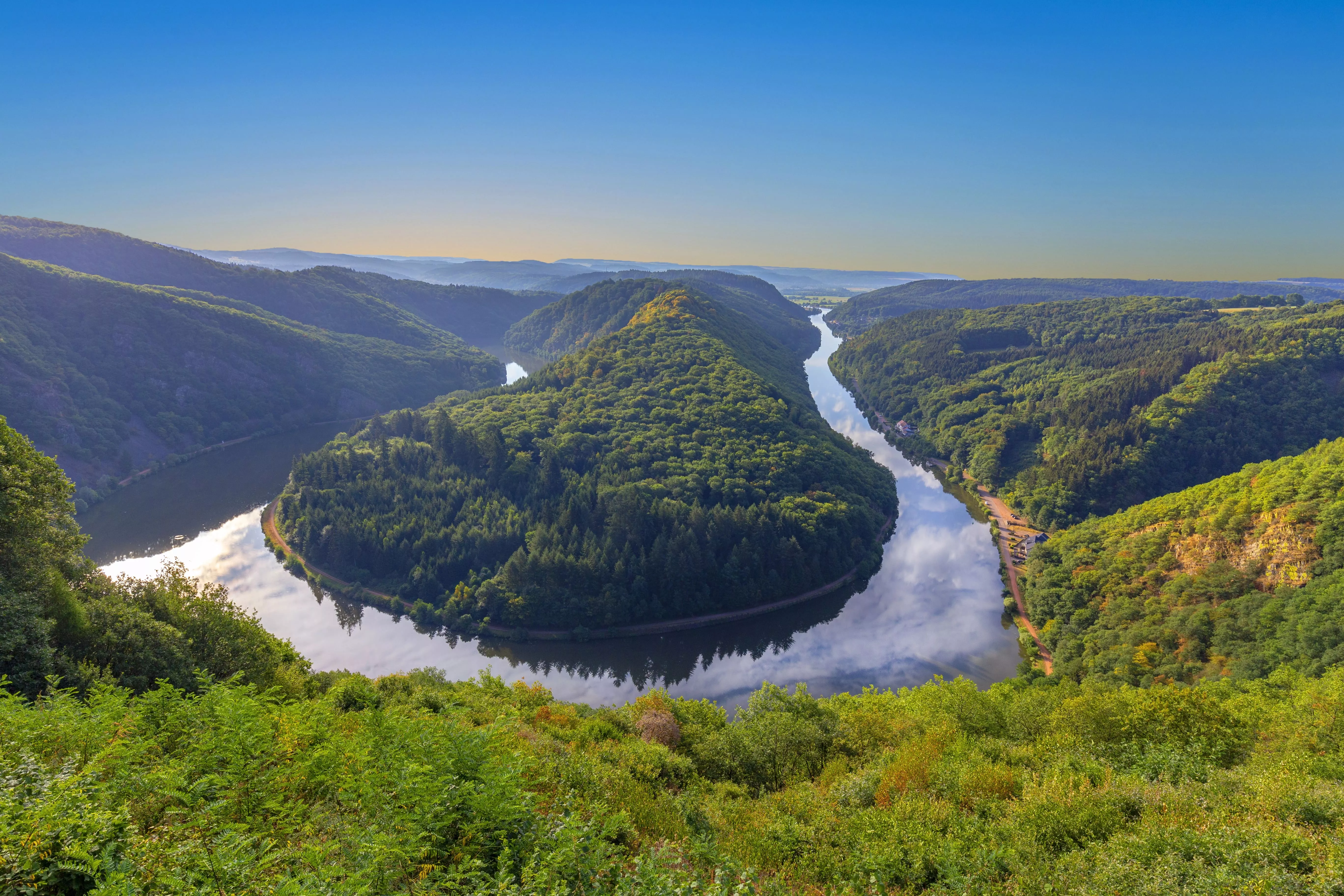 Panoramisch uitzicht op de Saarbocht bij Mettlach, met dichte bossen en een slingerende rivier.