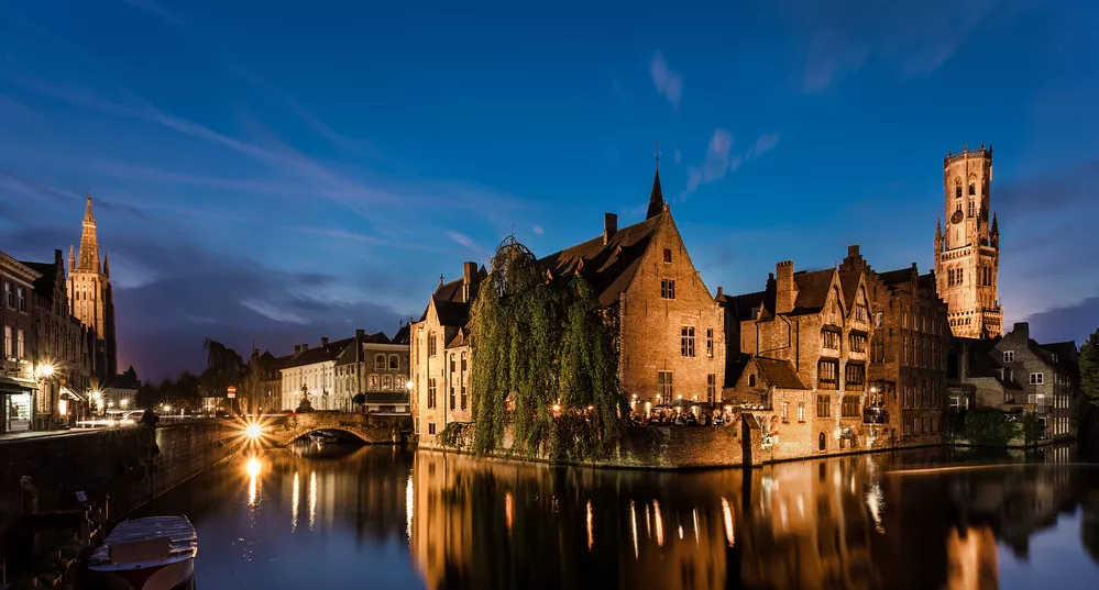 stenen gebouw 's avonds aan het water in Brugge, België